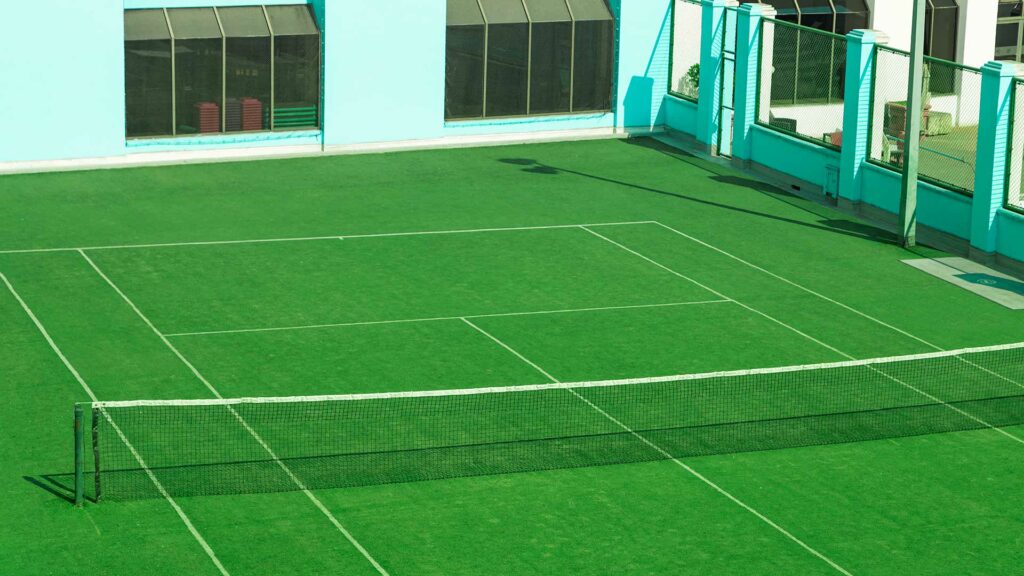 What are the ideal dimensions for a grass tennis court?